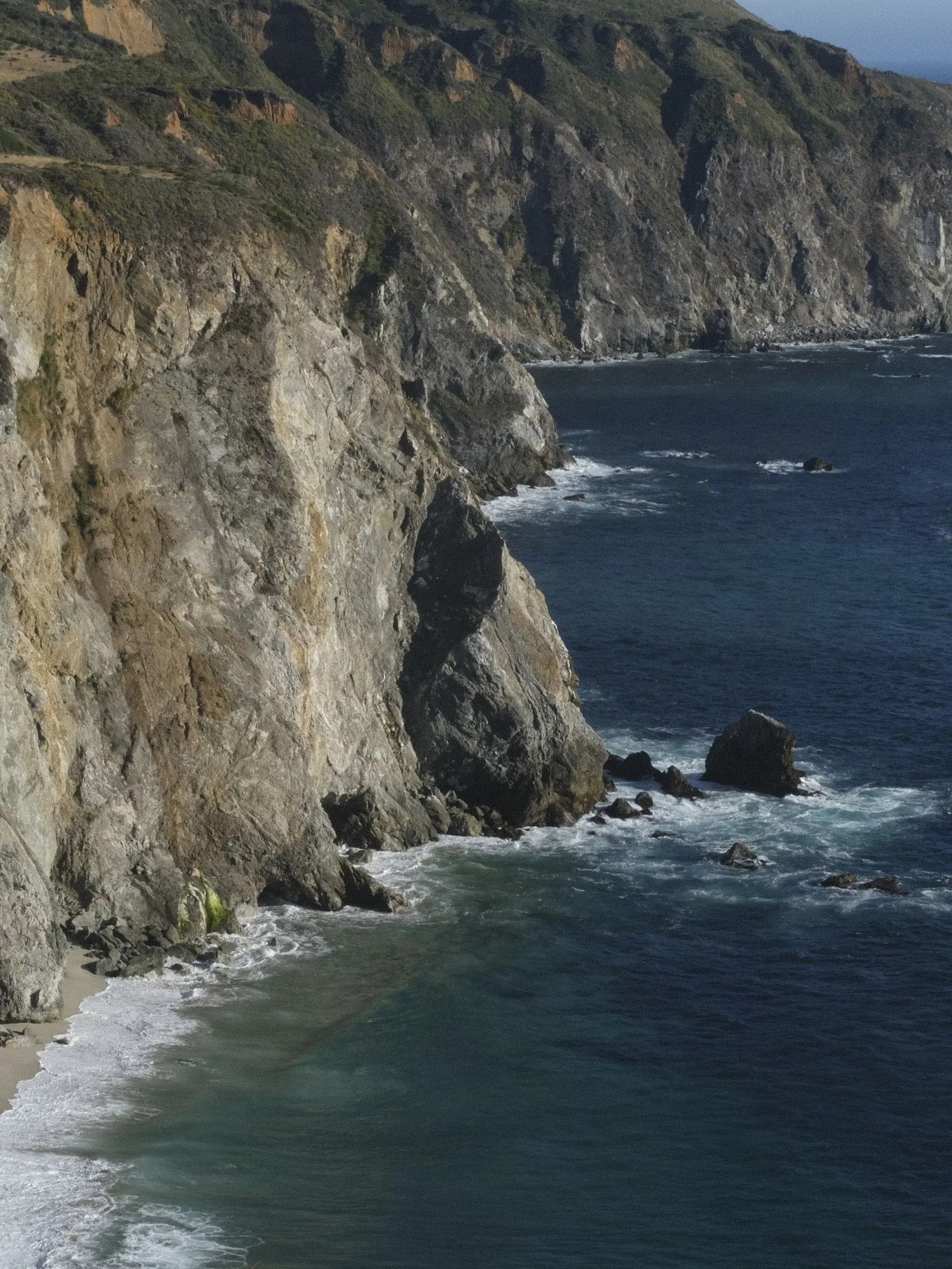 Steep cliffs meeting deep blue water on the Monterey coast
